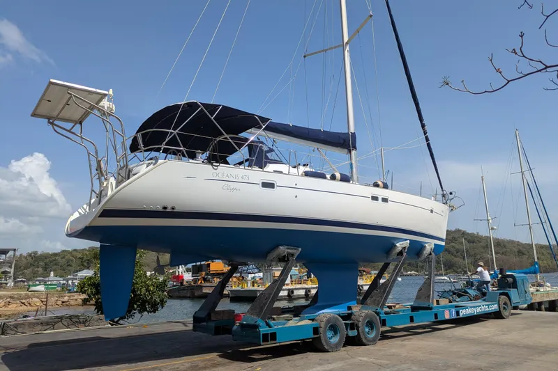 Laylay Yacht Photos Pics 2003 Beneteau Oceanis Clipper 473 sailboat on trailer at marina, clear sky background.