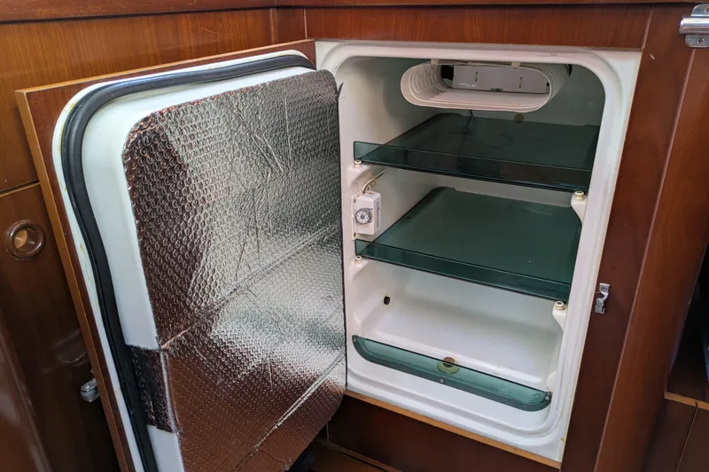 Laylay Yacht Photos Pics Open refrigerator inside 2003 Beneteau Oceanis Clipper 473 yacht, featuring glass shelves.