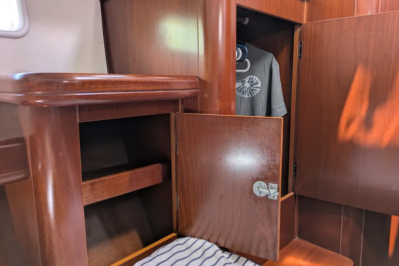 Laylay Yacht Photos Pics Interior of 2003 Beneteau Oceanis Clipper 473 with wooden cabinetry and hanging clothes.