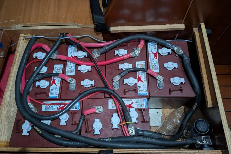 Laylay Yacht Photos Pics Battery compartment of a 2003 Beneteau Oceanis Clipper 473 sailboat, showing multiple connected batteries.