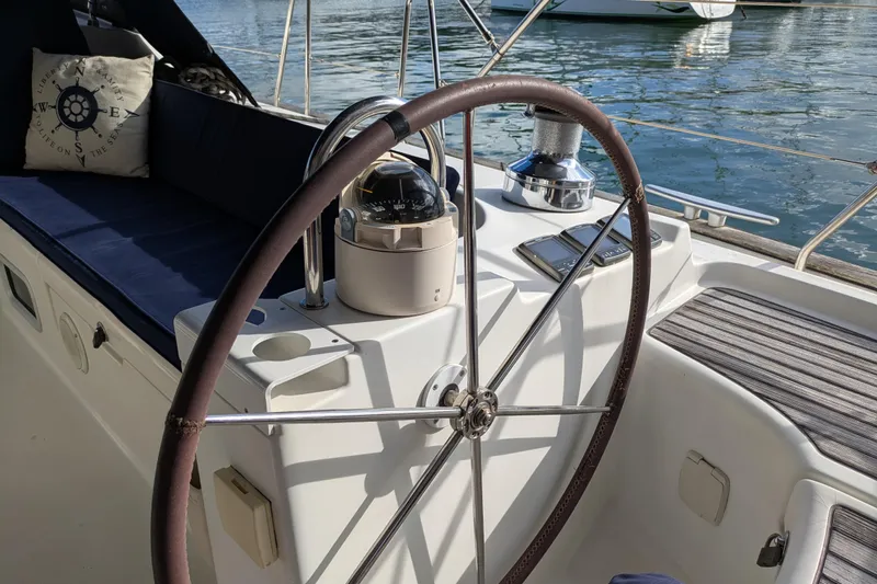 Laylay Yacht Photos Pics Steering wheel of 2003 Beneteau Oceanis Clipper 473 sailboat with compass and seating.