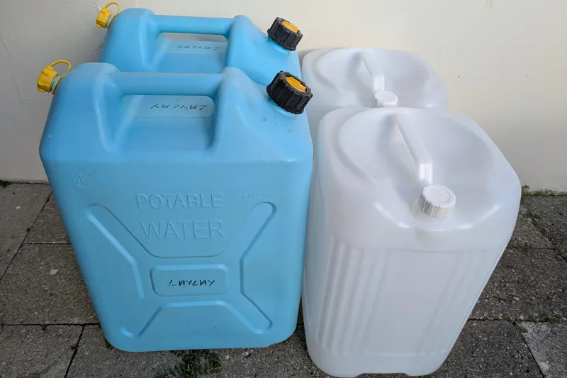 Laylay Yacht Photos Pics Blue and white water containers on pavement, labeled "Potable Water," for Beneteau Oceanis Clipper 473.
