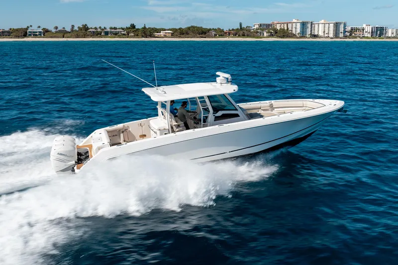  Yacht Photos Pics 2019 Boston Whaler 380 Outrage cruising on open water near coastline.
