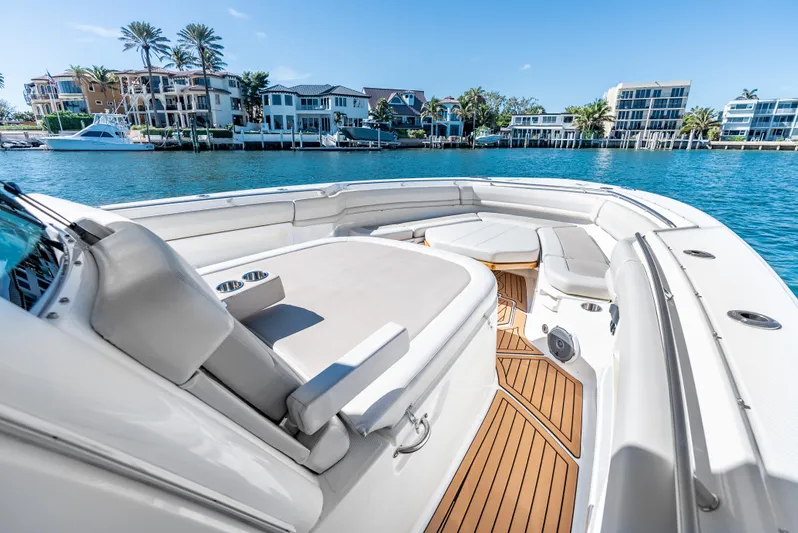  Yacht Photos Pics 2019 Boston Whaler 380 Outrage boat with luxurious seating, docked near waterfront homes.