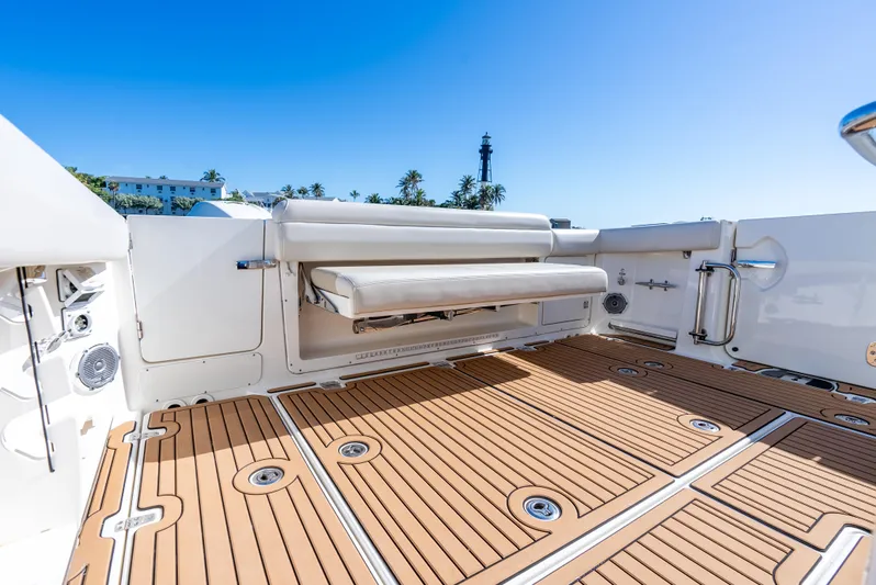  Yacht Photos Pics 2019 Boston Whaler 380 Outrage boat deck with seating, featuring teak flooring and clear blue sky.
