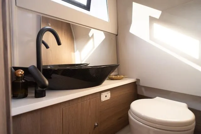  Yacht Photos Pics Modern bathroom in 2026 Virtue V10 with sleek black fixtures and wooden cabinetry.