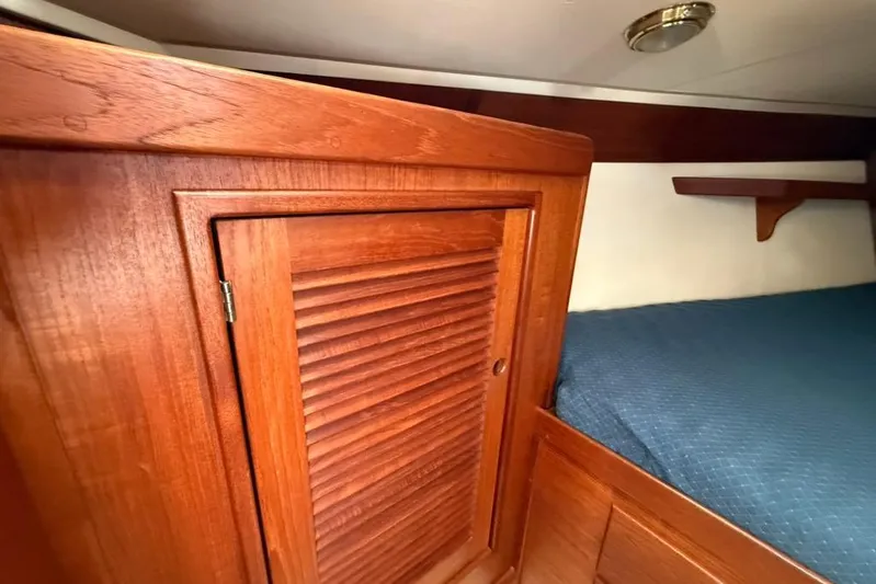  Yacht Photos Pics 1998 Tartan 3500 yacht interior with wooden cabinet and blue bedding.