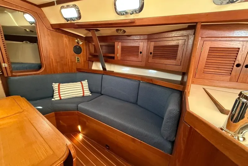  Yacht Photos Pics Cozy interior of 1998 Tartan 3500 sailboat with wooden cabinetry and blue seating.