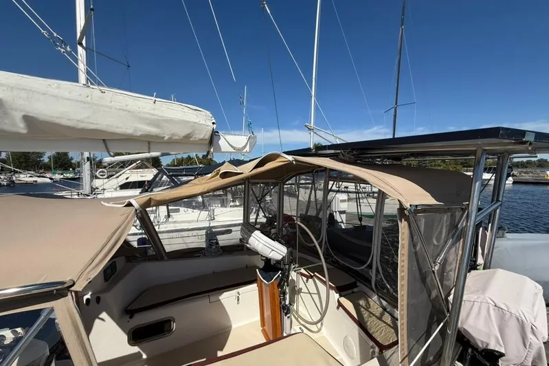  Yacht Photos Pics 1998 Tartan 3500 sailboat cockpit with beige canopy, docked at marina under clear blue sky.