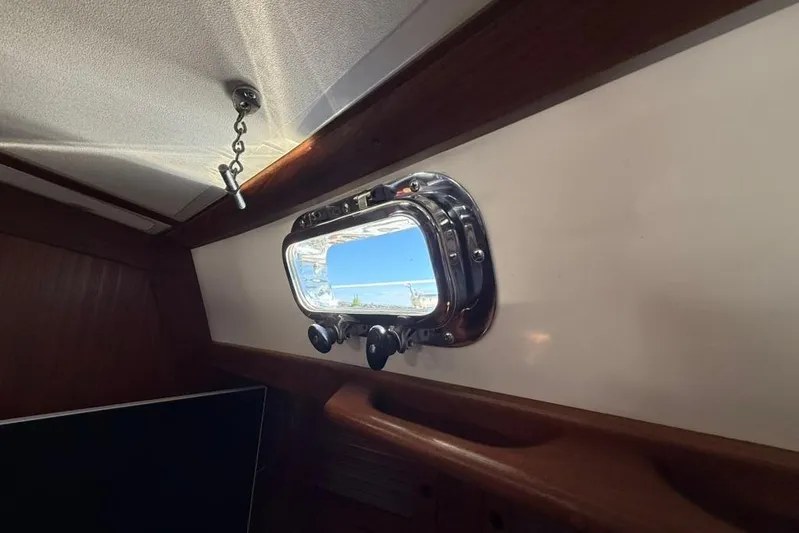  Yacht Photos Pics Interior view of a 1998 Tartan 3500 sailboat with a porthole window.