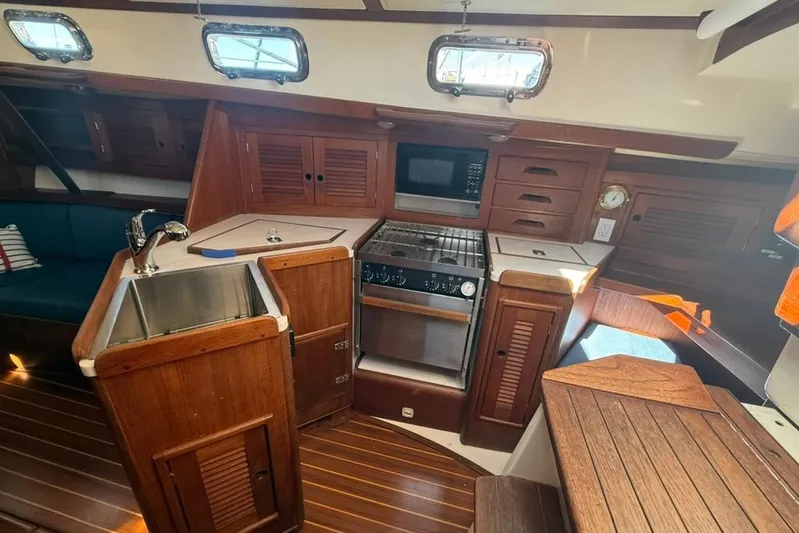  Yacht Photos Pics Interior of a 1998 Tartan 3500 sailboat kitchen with wood cabinetry and appliances.