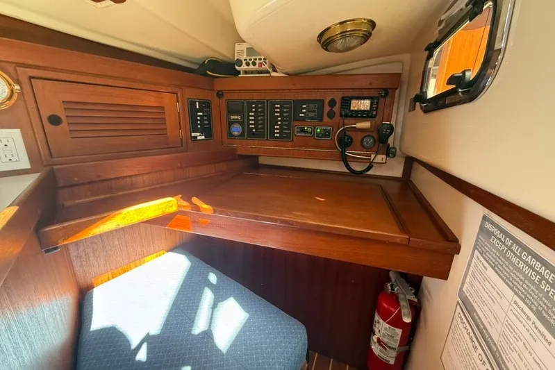  Yacht Photos Pics Navigation station inside a 1998 Tartan 3500 sailboat, featuring control panels and a fire extinguisher.