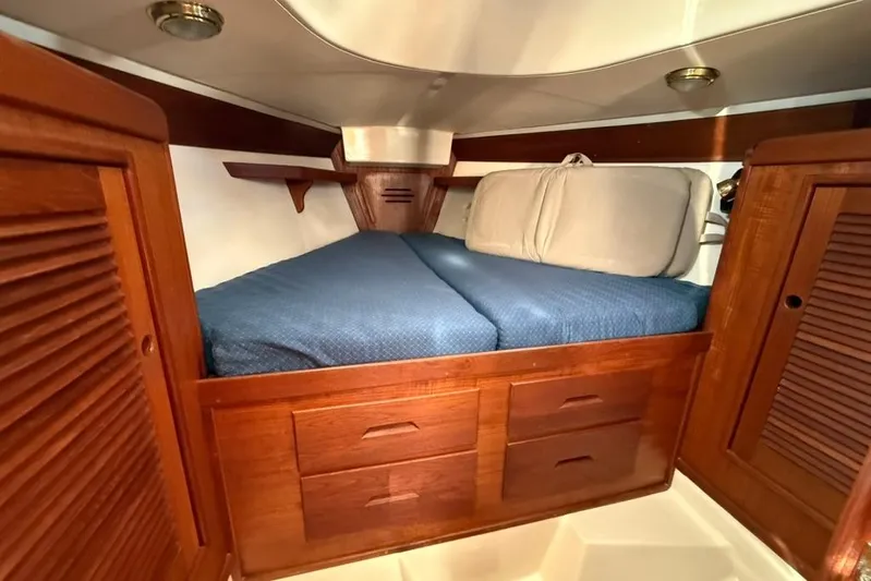  Yacht Photos Pics Cozy cabin interior of 1998 Tartan 3500 sailboat with wooden storage and blue bedding.