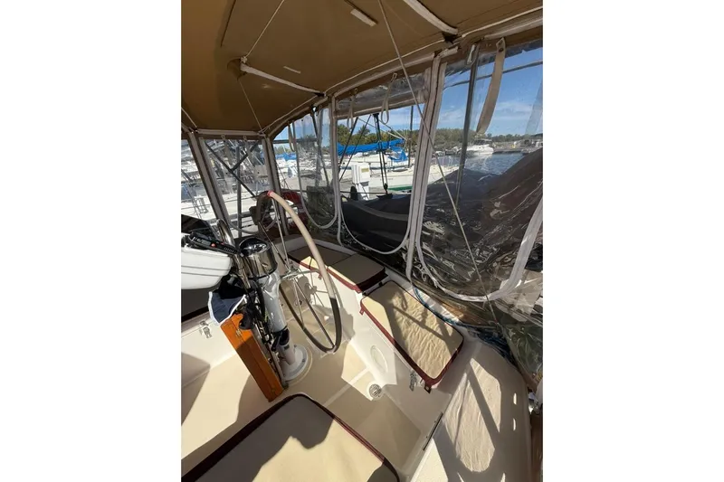  Yacht Photos Pics 1998 Tartan 3500 sailboat cockpit with steering wheel, canopy, and marina view.