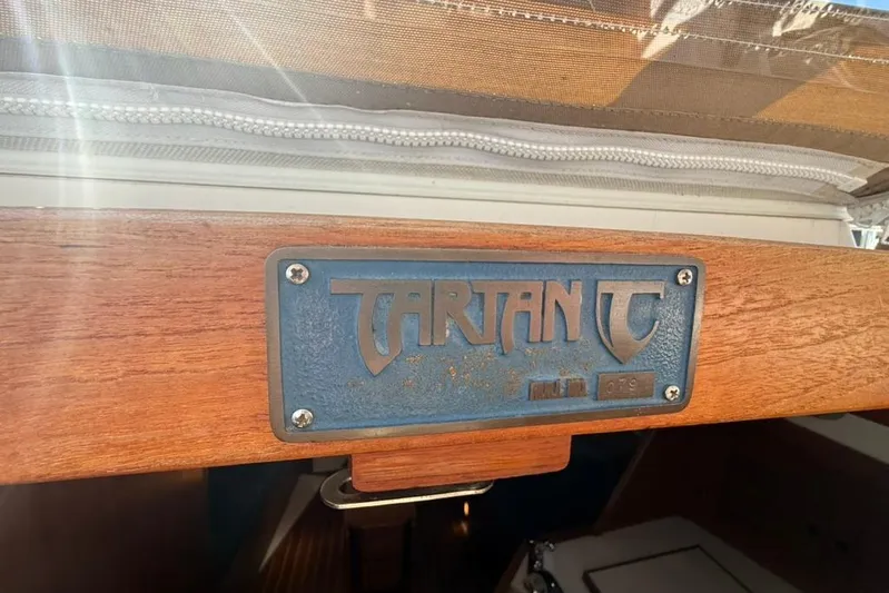  Yacht Photos Pics 1998 Tartan 3500 sailboat nameplate on wooden surface, sunlight filtering through.