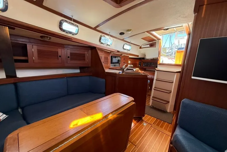  Yacht Photos Pics Interior of a 1998 Tartan 3500 sailboat with wooden cabinetry and blue seating.
