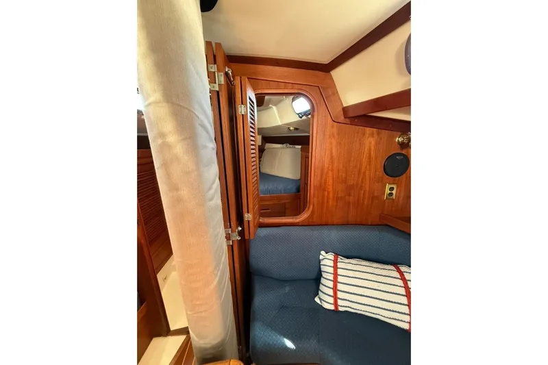  Yacht Photos Pics Interior of a 1998 Tartan 3500 sailboat with wooden cabinetry and blue seating.