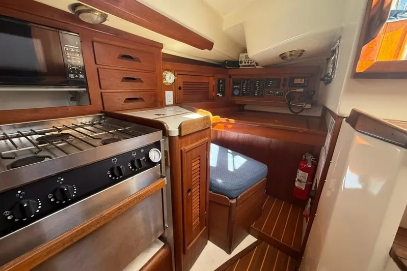 Yacht Photos Pics 1998 Tartan 3500 yacht interior with kitchen, navigation area, and wooden cabinetry.