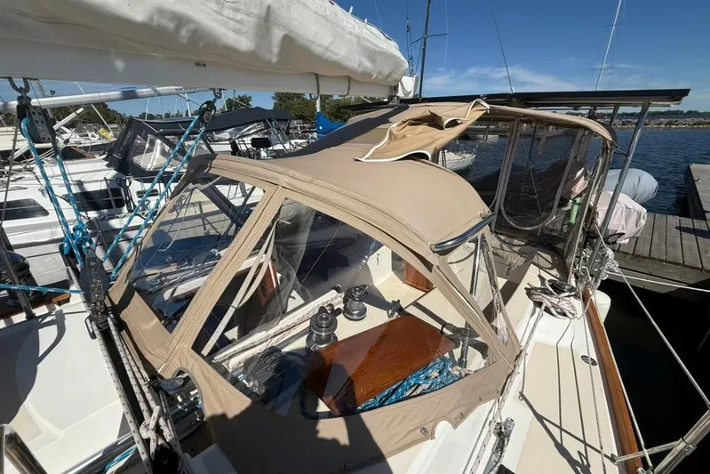  Yacht Photos Pics 1998 Tartan 3500 sailboat docked, featuring beige canopy and blue ropes under clear sky.