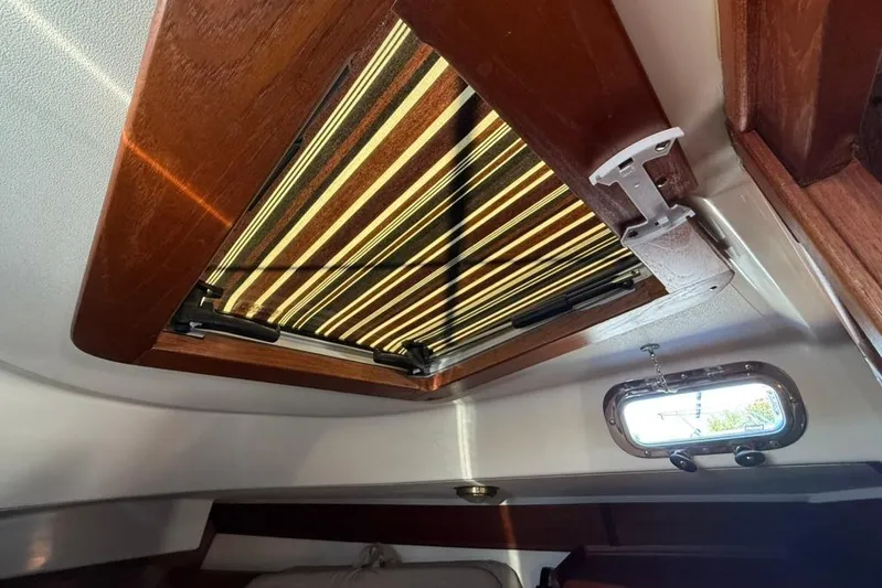  Yacht Photos Pics Interior view of a 1998 Tartan 3500 sailboat hatch with wooden trim and striped cover.