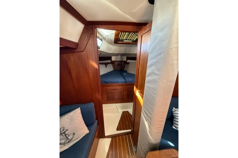  Yacht Photos Pics Cozy interior of 1998 Tartan 3500 sailboat with wooden finish and blue upholstery.