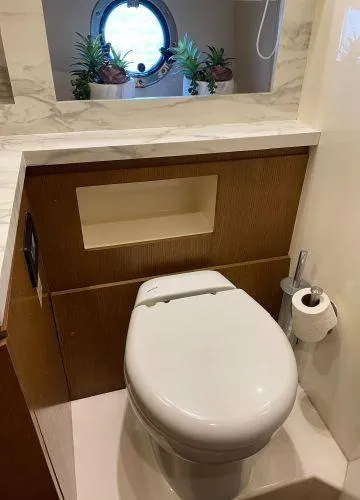  Yacht Photos Pics Luxury yacht bathroom with modern toilet, porthole window, and elegant decor on Azimut Atlantis 43.