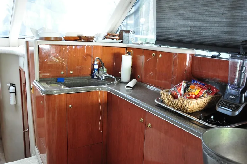  Yacht Photos Pics 1998 Sea Ray 480 Sedan Bridge kitchen with wooden cabinets and countertop appliances.