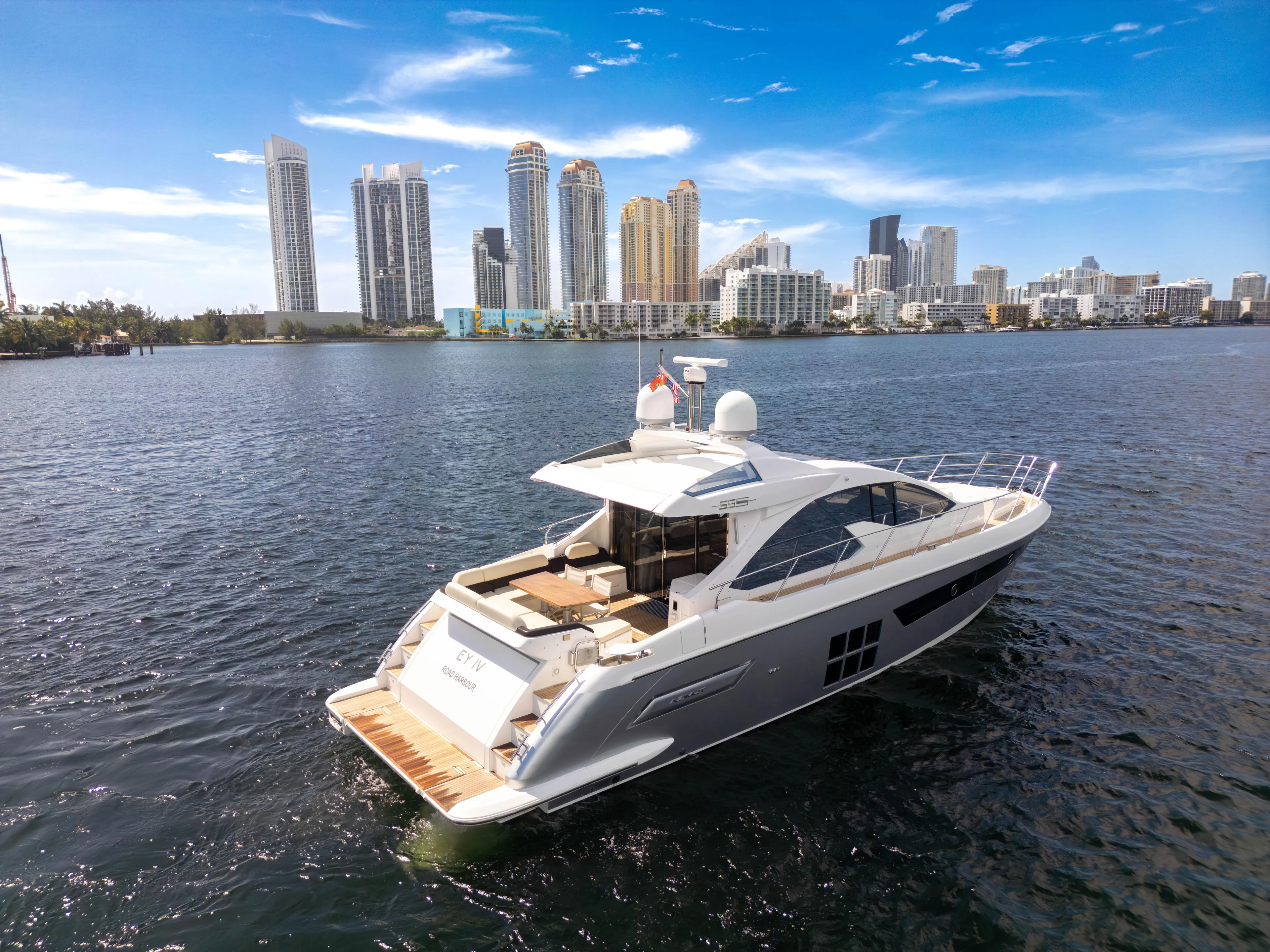 Ey IV Yacht Photos Pics 2016 Azimut 55S yacht cruising near city skyline under clear blue sky.