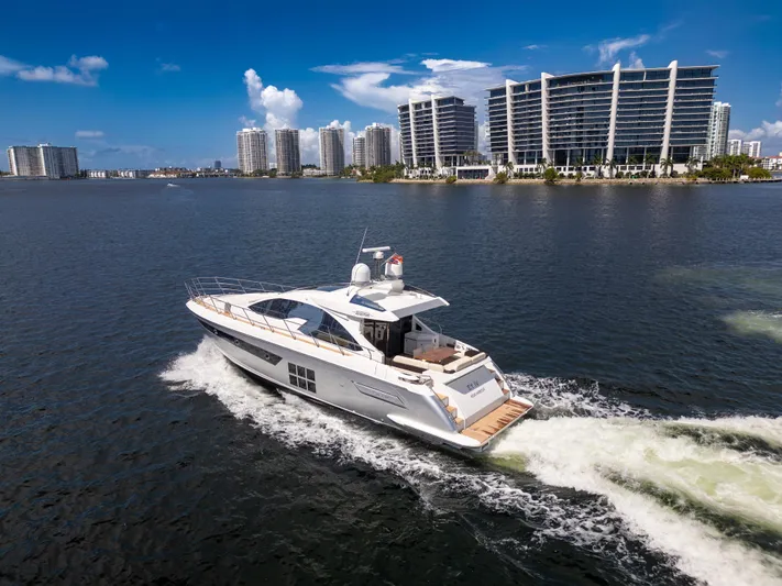 Ey IV Yacht Photos Pics 2016 Azimut 55S yacht cruising near modern waterfront buildings under a clear blue sky.
