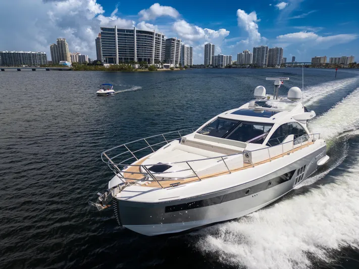 Ey IV Yacht Photos Pics 2016 Azimut 55S yacht cruising in a scenic urban waterway with modern buildings.