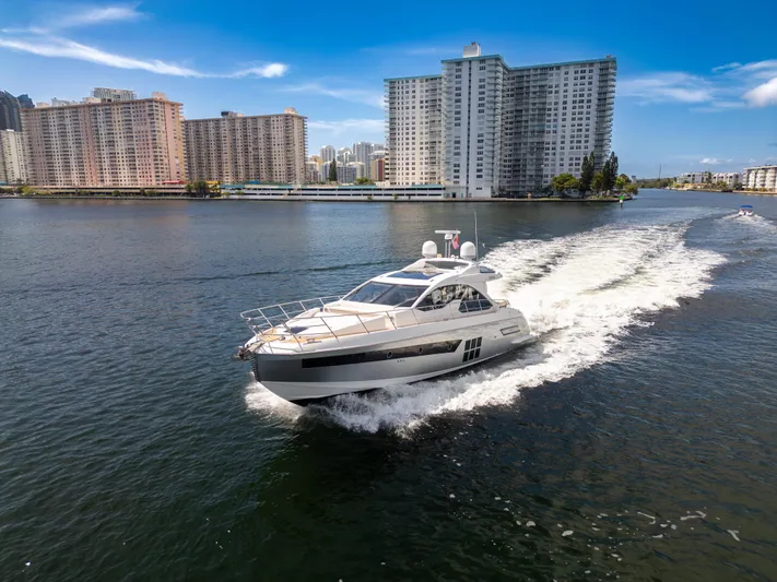 Ey IV Yacht Photos Pics 2016 Azimut 55S yacht cruising in urban waterfront setting, high-rise buildings in background.