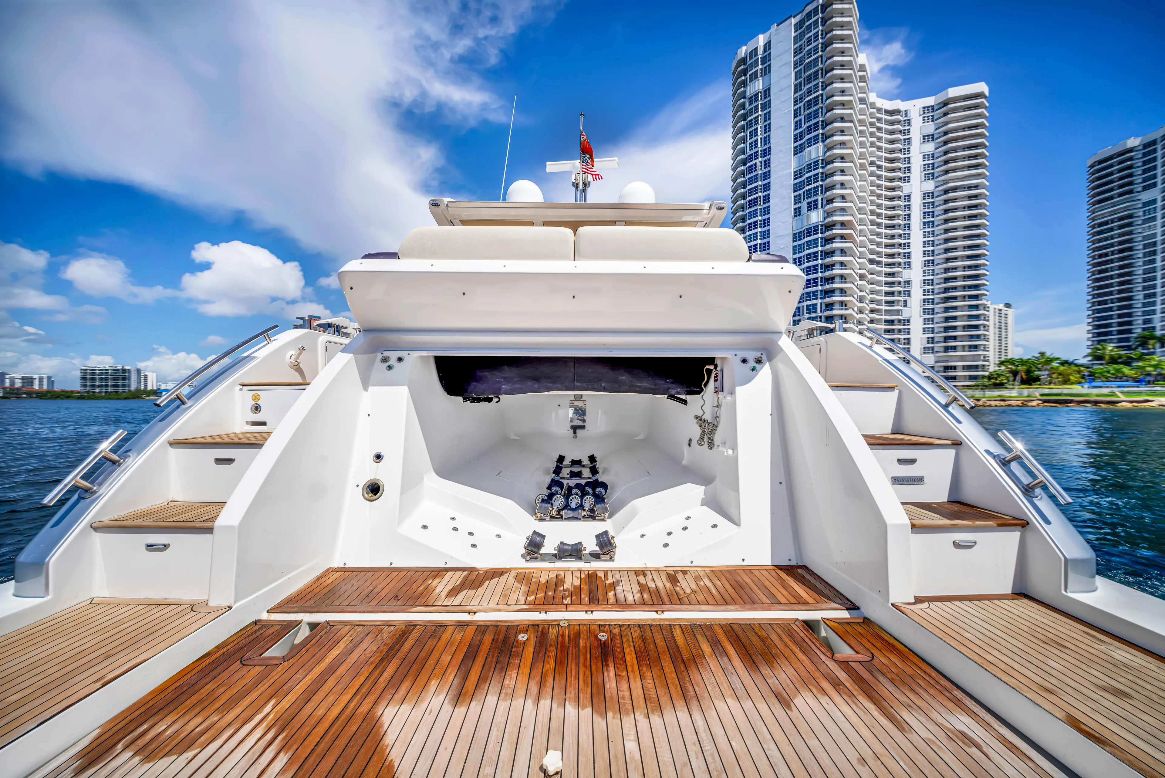 Ey IV Yacht Photos Pics 2016 Azimut 55S yacht with wooden deck, city skyline in background.