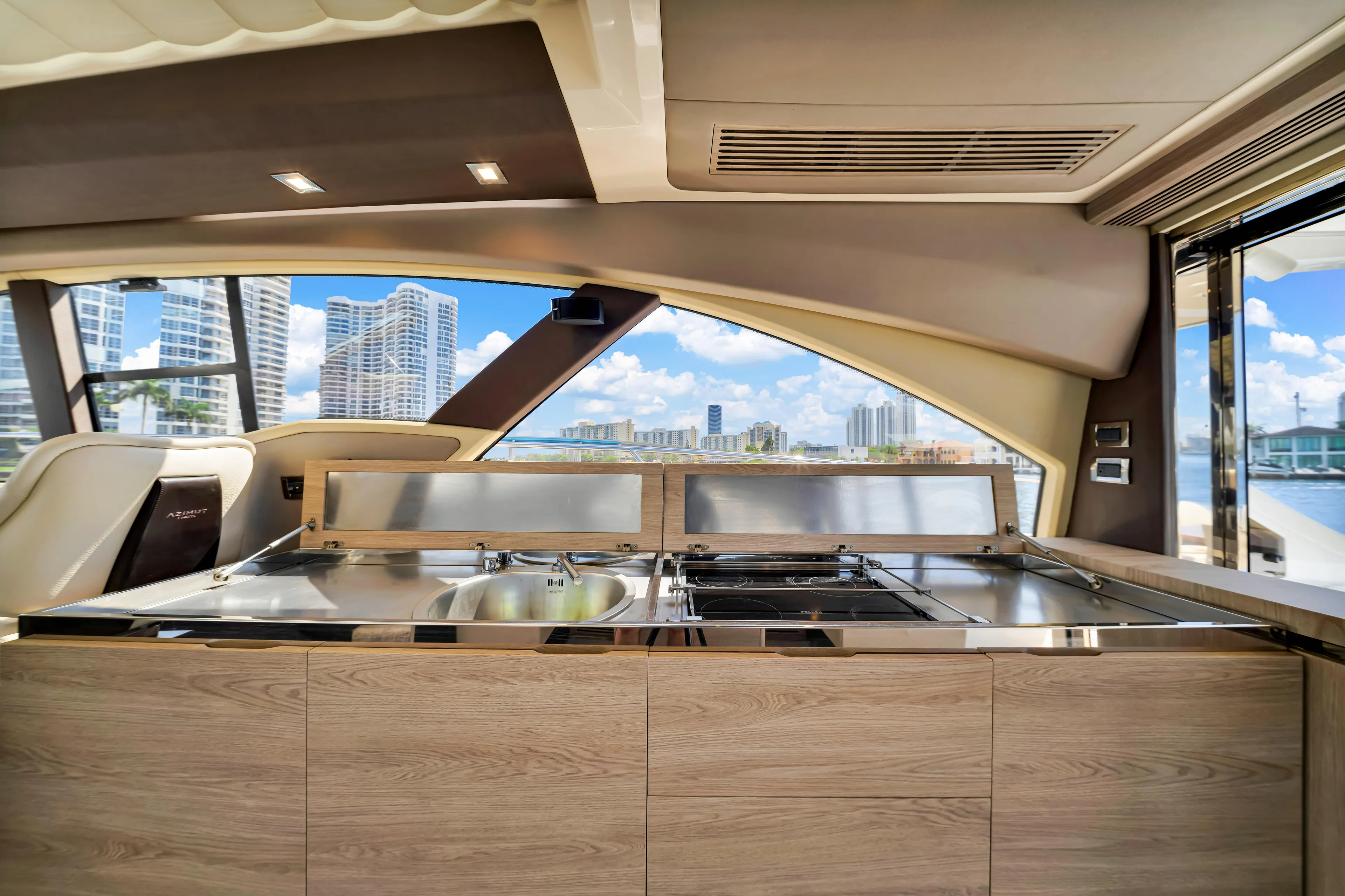 Ey IV Yacht Photos Pics Interior view of 2016 Azimut 55S yacht kitchen with cityscape background.