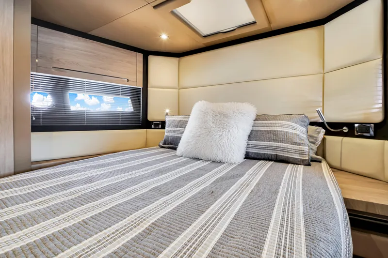 Ey IV Yacht Photos Pics Luxurious bedroom interior of 2016 Azimut 55S yacht with striped bedding and plush pillow.
