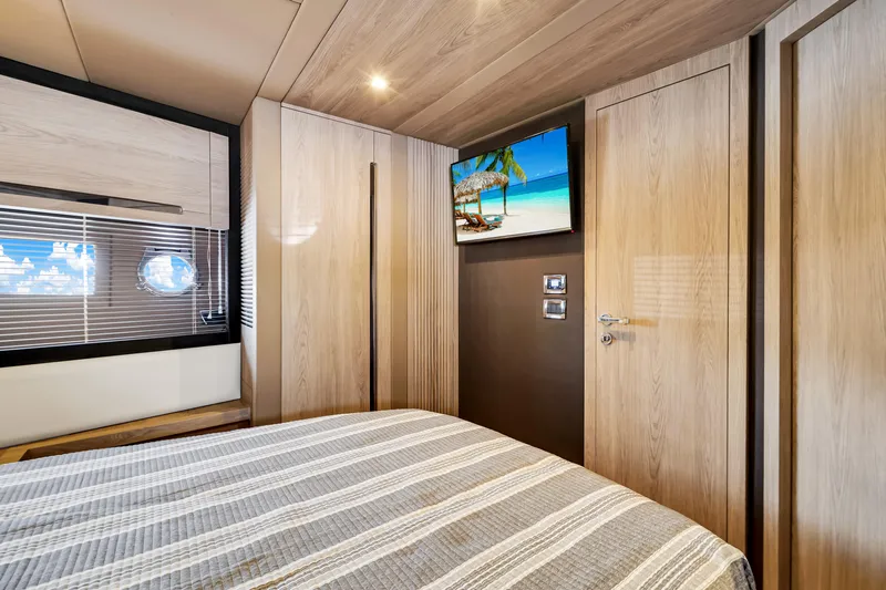 Ey IV Yacht Photos Pics Luxurious bedroom interior of 2016 Azimut 55S yacht with modern wood finishes and scenic artwork.