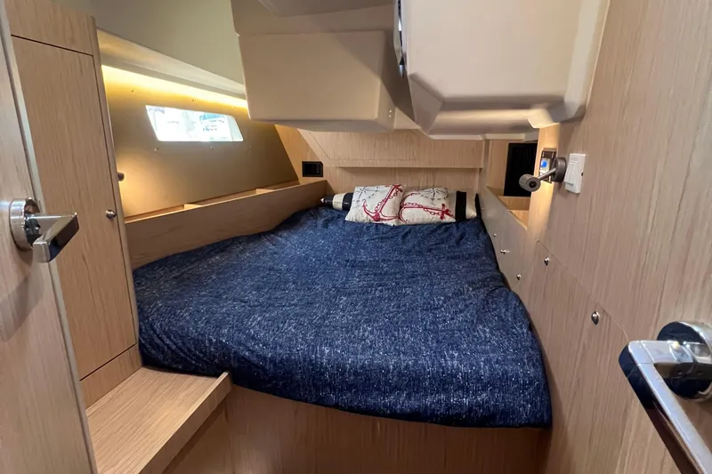  Yacht Photos Pics Cozy cabin interior of 2019 Beneteau Oceanis 41.1 sailboat with blue bedding.