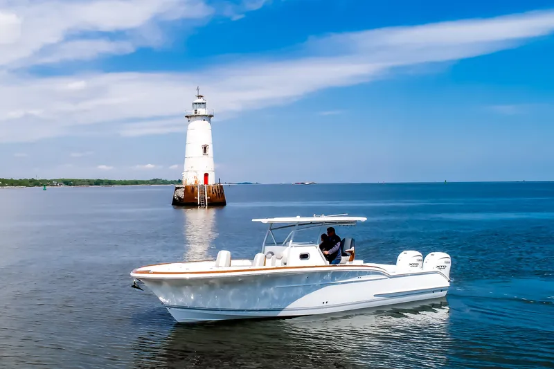  Yacht Photos Pics 2019 Buddy Davis 34 Center Console boat near a lighthouse on calm waters.