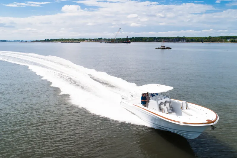  Yacht Photos Pics 2019 Buddy Davis 34 Center Console cruising on open water, creating a dynamic wake.