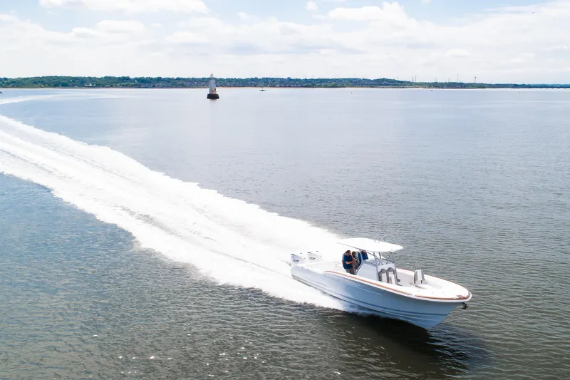  Yacht Photos Pics 2019 Buddy Davis 34 Center Console boat cruising on open water, leaving a wake.