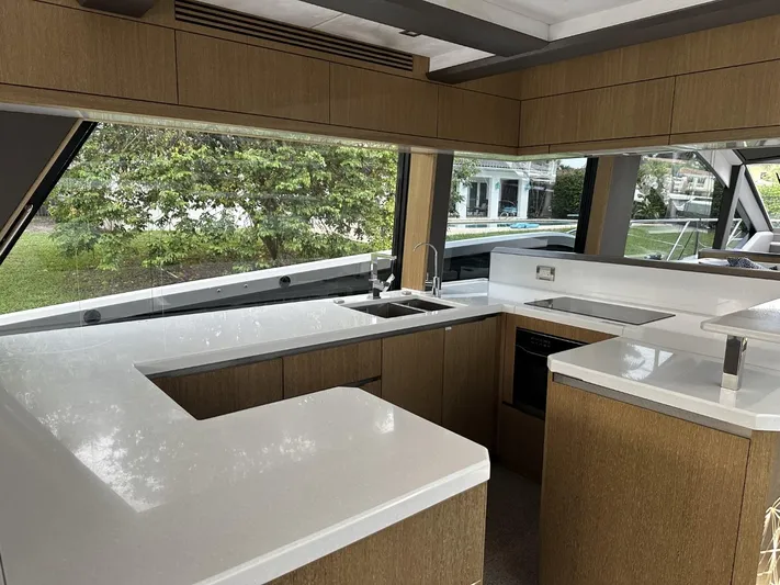 Yacht Photos Pics Modern kitchen interior of 2019 Galeon 650 Sky yacht with sleek countertops and large windows.