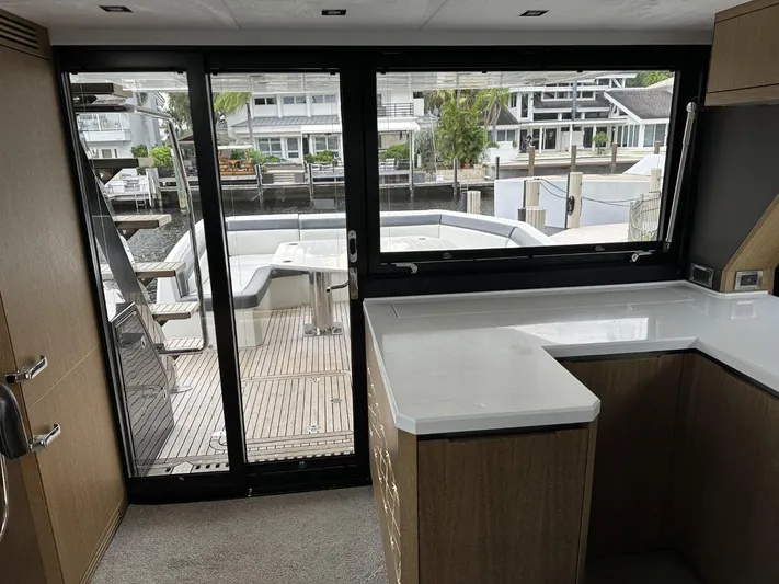  Yacht Photos Pics Interior view of 2019 Galeon 650 Sky yacht with modern kitchen and deck access.