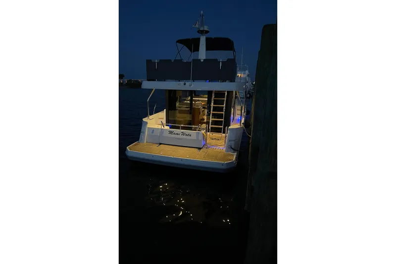  Yacht Photos Pics 2025 Beneteau Swift Trawler 41 Fly docked at night with illuminated deck.