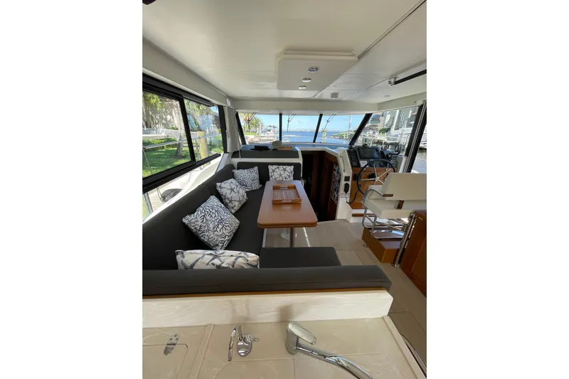  Yacht Photos Pics Interior of 2025 Beneteau Swift Trawler 41 Fly, featuring seating, table, and helm station.