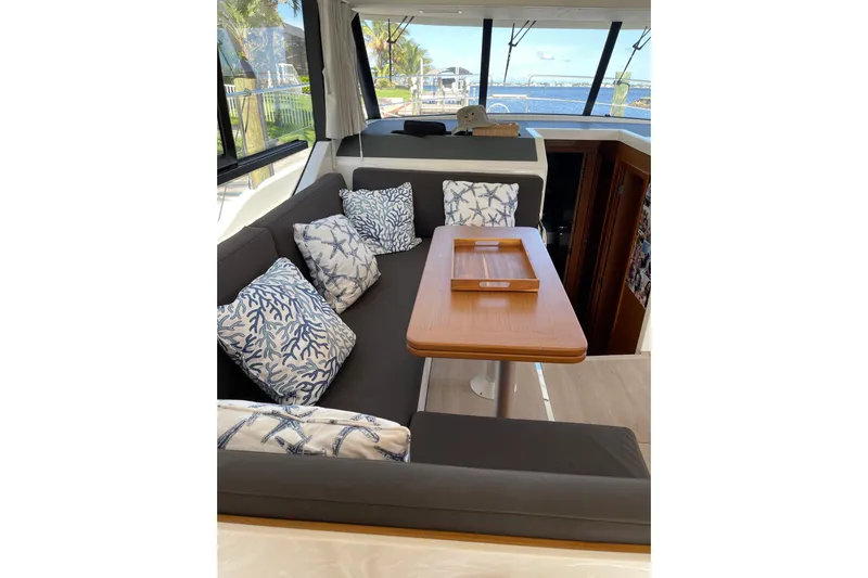  Yacht Photos Pics Interior of 2025 Beneteau Swift Trawler 41 Fly with cozy seating and nautical-themed cushions.
