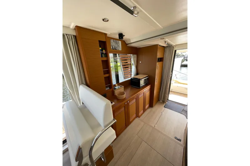  Yacht Photos Pics Interior of 2025 Beneteau Swift Trawler 41 Fly, featuring modern wood cabinetry and seating.