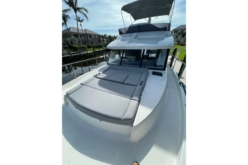  Yacht Photos Pics 2025 Beneteau Swift Trawler 41 Fly with sun deck, docked near waterfront homes.