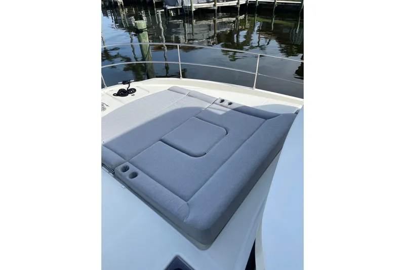  Yacht Photos Pics 2025 Beneteau Swift Trawler 41 Fly sunpad, docked by calm waters.