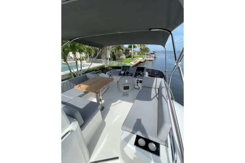  Yacht Photos Pics 2025 Beneteau Swift Trawler 41 Fly, spacious flybridge with seating and table, dockside view.