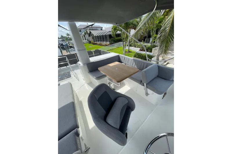  Yacht Photos Pics Flybridge seating area on 2025 Beneteau Swift Trawler 41 Fly, featuring comfortable chairs and table.