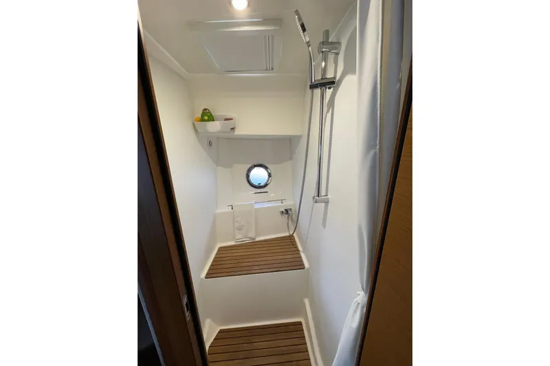  Yacht Photos Pics 2025 Beneteau Swift Trawler 41 Fly shower with wooden flooring and modern fixtures.